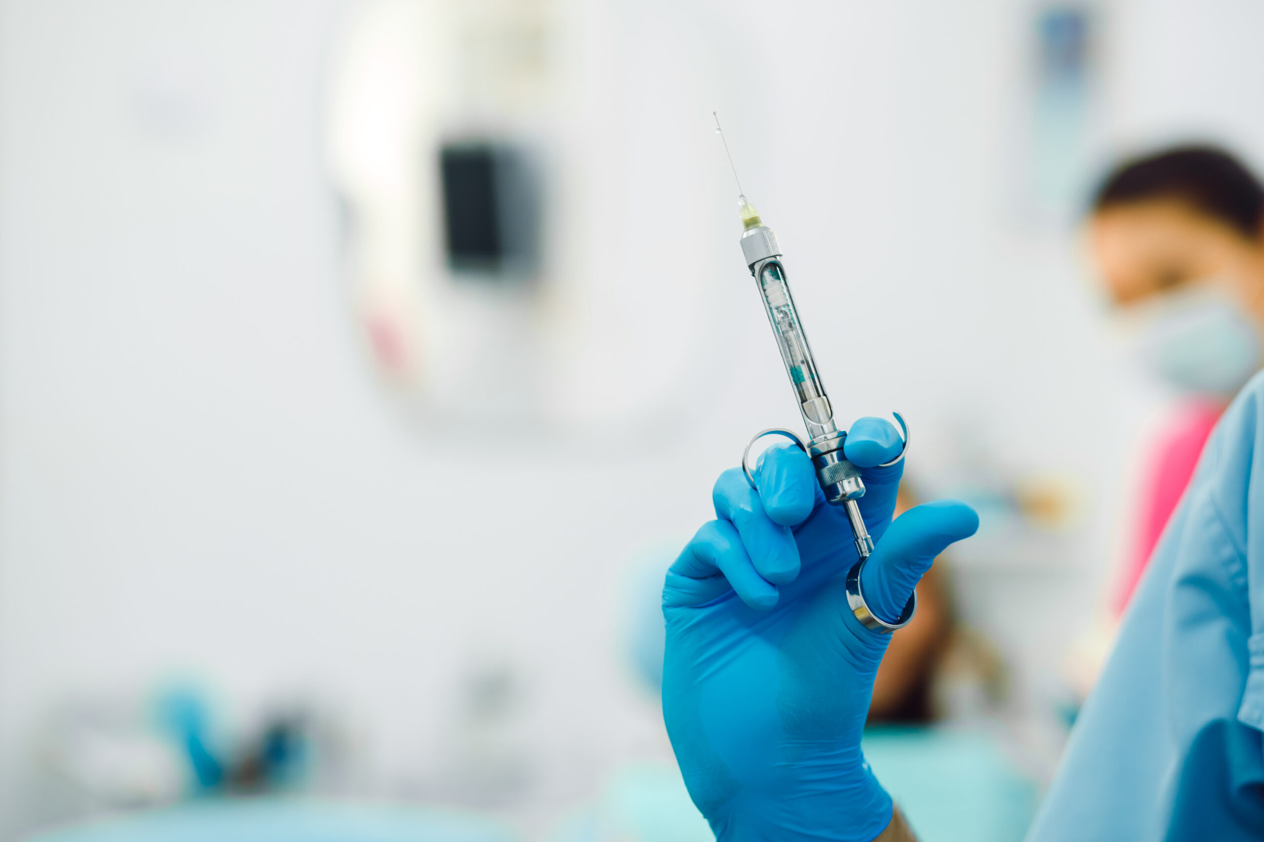 Dental anesthesia on the background of the patient Assistant dentist and the patient in the clinic.